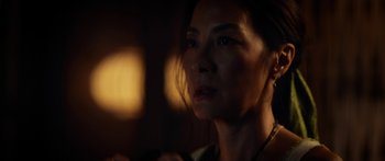 Movie still from “Mechanic: Resurrection” (2016), directed by Dennis Gansel – A woman's face in a dimly - lit room; Close Up shot, Over the shoulder angle