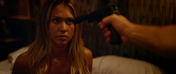 Movie still from “Mechanic: Resurrection” (2016), directed by Dennis Gansel – A woman sitting in front of a man holding a gun; Close Up shot, Over the shoulder angle