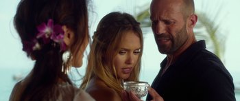 Movie still from “Mechanic: Resurrection” (2016), directed by Dennis Gansel – Two women and a man holding a cup of coffee; Close Up shot, Over the shoulder angle