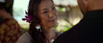 Movie still from “Mechanic: Resurrection” (2016), directed by Dennis Gansel – A person with a flower in her hair; Close Up shot, Over the shoulder angle