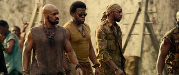 Movie still from “Mechanic: Resurrection” (2016), directed by Dennis Gansel – A group of men walking down a street; Medium shot, Low angle