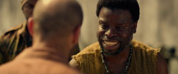 Movie still from “Mechanic: Resurrection” (2016), directed by Dennis Gansel – A man with a beard is talking to another man; Close Up shot, Over the shoulder angle