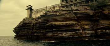 Movie still from “Mechanic: Resurrection” (2016), directed by Dennis Gansel – A person jumping off a cliff into the ocean; Extreme Wide shot, Low angle