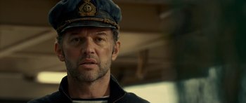 Movie still from “Mechanic: Resurrection” (2016), directed by Dennis Gansel – A person wearing a hat; Close Up shot, Over the shoulder angle