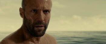 Movie still from “Mechanic: Resurrection” (2016), directed by Dennis Gansel – A person with wet hair and a beard; Close Up shot, Over the shoulder angle