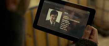 Movie still from “Mechanic: Resurrection” (2016), directed by Dennis Gansel – A person holding a tablet with a picture of a man on it; Close Up shot, High angle