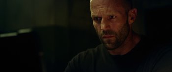 Movie still from “Mechanic: Resurrection” (2016), directed by Dennis Gansel – A person wearing a black t - shirt; Close Up shot, Low angle
