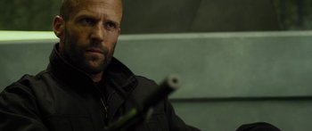 Movie still from “Mechanic: Resurrection” (2016), directed by Dennis Gansel – A bald man with a gun in his hand; Close Up shot, Low angle