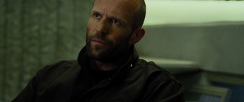 Movie still from “Mechanic: Resurrection” (2016), directed by Dennis Gansel – A man with a bald head is looking at the camera; Close Up shot, Over the shoulder angle