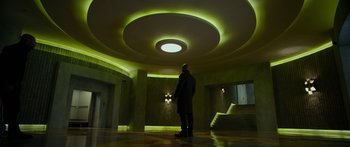 Movie still from “Mechanic: Resurrection” (2016), directed by Dennis Gansel – A man standing in a room lit up with green lights; Wide shot, Low angle
