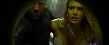 Movie still from “Mechanic: Resurrection” (2016), directed by Dennis Gansel – A man and a woman are standing next to each other; Close Up shot, Low angle