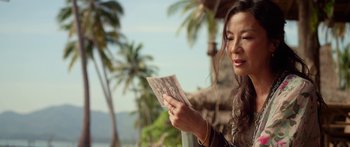 Movie still from “Mechanic: Resurrection” (2016), directed by Dennis Gansel – A woman looking at an old picture of a family; Close Up shot, Over the shoulder angle