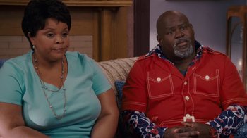 Movie still from “Meet the Browns” (2008), directed by Tyler Perry – A man and a woman sitting on a couch together; Medium shot, High angle