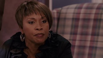 Movie still from “Meet the Browns” (2008), directed by Tyler Perry – A woman sitting on a couch looking at the camera; Close Up shot, Over the shoulder angle