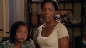 Movie still from “Meet the Browns” (2008), directed by Tyler Perry – A woman standing next to a young boy in a room; Medium shot, Over the shoulder angle