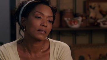 Movie still from “Meet the Browns” (2008), directed by Tyler Perry – A person sitting in front of a table; Close Up shot, Over the shoulder angle