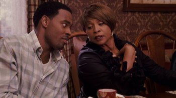 Movie still from “Meet the Browns” (2008), directed by Tyler Perry – A man and a woman sitting at a dinner table; Medium shot, Over the shoulder angle