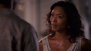 Movie still from “Meet the Browns” (2008), directed by Tyler Perry – A person wearing a necklace near a wall; Close Up shot, Over the shoulder angle