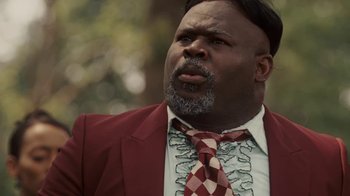 Movie still from “Meet the Browns” (2008), directed by Tyler Perry – A man in a red suit and a red and white neck tie; Close Up shot, Low angle