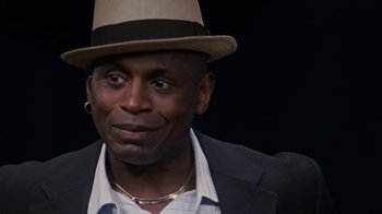 Movie still from “Meet the Browns” (2008), directed by Tyler Perry – A person wearing a suit and a hat; Close Up shot, Over the shoulder angle