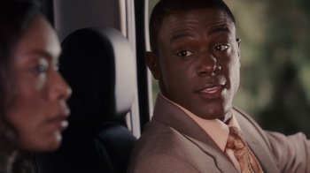 Movie still from “Meet the Browns” (2008), directed by Tyler Perry – A person wearing a suit and tie; Close Up shot, Over the shoulder angle