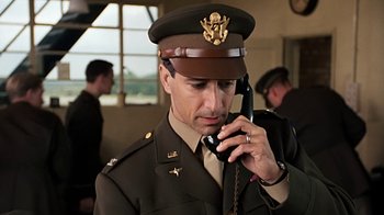 Movie still from “Memphis Belle” (1990), directed by Michael Caton-Jones – A man in uniform talking on a cell phone; Close Up shot, Low angle
