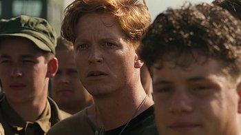 Movie still from “Memphis Belle” (1990), directed by Michael Caton-Jones – A person wearing a black shirt; Close Up shot, Over the shoulder angle