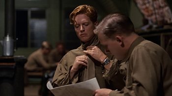 Movie still from “Memphis Belle” (1990), directed by Michael Caton-Jones – A man and a woman looking at a piece of paper; Medium shot, Over the shoulder angle
