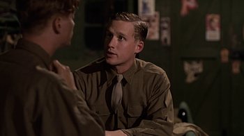 Movie still from “Memphis Belle” (1990), directed by Michael Caton-Jones – A man wearing a suit and tie talking to another man; Close Up shot, Over the shoulder angle