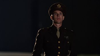Movie still from “Memphis Belle” (1990), directed by Michael Caton-Jones – A man in a military uniform standing in the dark; Medium shot, Low angle