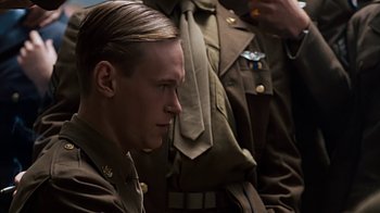 Movie still from “Memphis Belle” (1990), directed by Michael Caton-Jones – A young man in military uniform sitting next to another man in uniform; Close Up shot, Low angle
