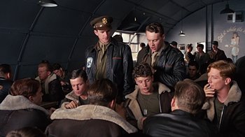 Movie still from “Memphis Belle” (1990), directed by Michael Caton-Jones – A group of young men sitting around a room; Medium shot, High angle