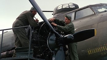 Movie still from “Memphis Belle” (1990), directed by Michael Caton-Jones – Two men working on an airplane engine; Wide shot, Low angle