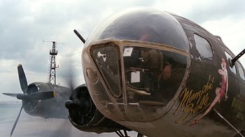 Movie still from “Memphis Belle” (1990), directed by Michael Caton-Jones – An airplane with a pilot sitting in the cockpit; Wide shot, Low angle