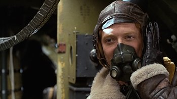 Movie still from “Memphis Belle” (1990), directed by Michael Caton-Jones – A man wearing a gas mask and a leather jacket; Close Up shot, Low angle