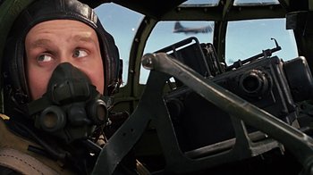 Movie still from “Memphis Belle” (1990), directed by Michael Caton-Jones – A man in the cockpit of an airplane; Close Up shot, Low angle