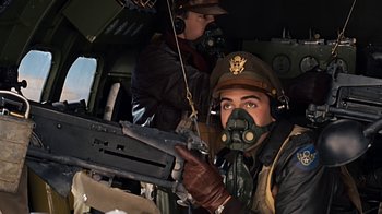 Movie still from “Memphis Belle” (1990), directed by Michael Caton-Jones – A man in a helmet is holding a rifle; Medium shot, Low angle