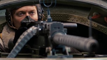 Movie still from “Memphis Belle” (1990), directed by Michael Caton-Jones – A man in a helmet looking into a machine gun compartment; Close Up shot, Over the shoulder angle