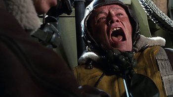 Movie still from “Memphis Belle” (1990), directed by Michael Caton-Jones – A man in a yellow jacket is screaming in the air; Close Up shot, Low angle