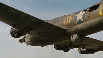 Movie still from “Memphis Belle” (1990), directed by Michael Caton-Jones – An old military plane flying in the sky; Wide shot, Low angle
