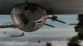 Movie still from “Memphis Belle” (1990), directed by Michael Caton-Jones – An old airplane is flying in the sky; Wide shot, Low angle