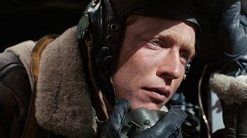 Movie still from “Memphis Belle” (1990), directed by Michael Caton-Jones – A person wearing a helmet and gloves; Close Up shot, Over the shoulder angle