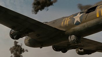 Movie still from “Memphis Belle” (1990), directed by Michael Caton-Jones – An old military plane is flying through the air; Wide shot, Low angle