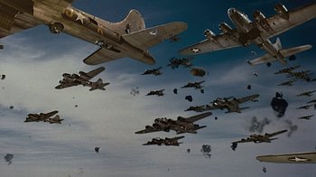 Movie still from “Memphis Belle” (1990), directed by Michael Caton-Jones – A group of airplanes flying in the sky; Extreme Wide shot, Low angle