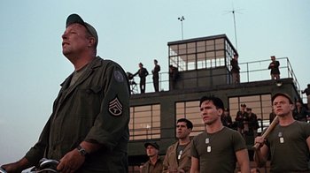Movie still from “Memphis Belle” (1990), directed by Michael Caton-Jones – A group of men standing next to each other on top of a building; Medium shot, Low angle