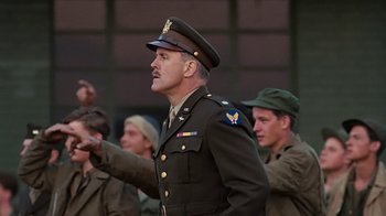 Movie still from “Memphis Belle” (1990), directed by Michael Caton-Jones – A man in a military uniform is pointing to something; Medium shot, Low angle