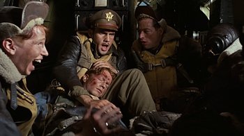 Movie still from “Memphis Belle” (1990), directed by Michael Caton-Jones – A group of men in uniform on top of an airplane; Medium shot, High angle