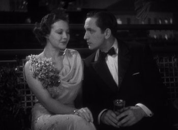 Movie still from “Merrily We Go to Hell” (1932), directed by Dorothy Arzner – A man and a woman sitting next to each other on a bench; Medium shot, High angle