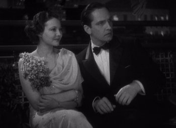 Movie still from “Merrily We Go to Hell” (1932), directed by Dorothy Arzner – A man and a woman sitting next to each other; Medium shot, High angle