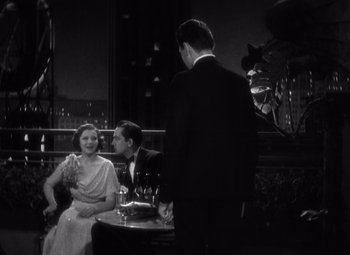 Movie still from “Merrily We Go to Hell” (1932), directed by Dorothy Arzner – A man and a woman sitting at a table; Medium shot, High angle